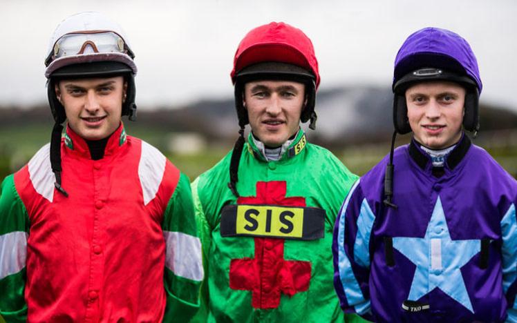 Three jockeys pose for a picture