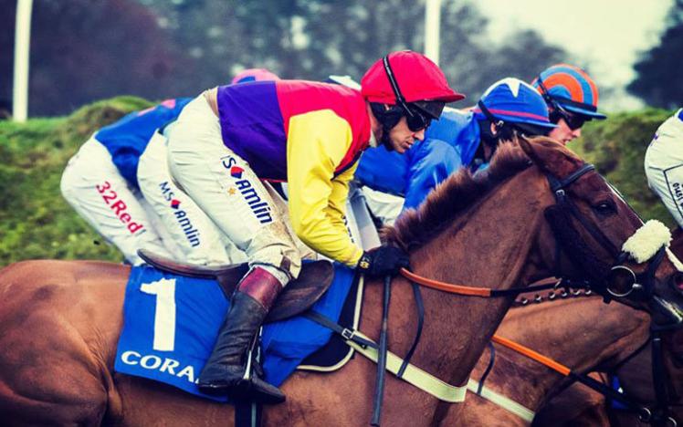 Horses and jockeys racing from left to right.