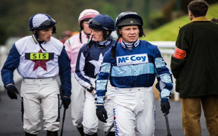 A group of Jockeys walk towards their meeting point