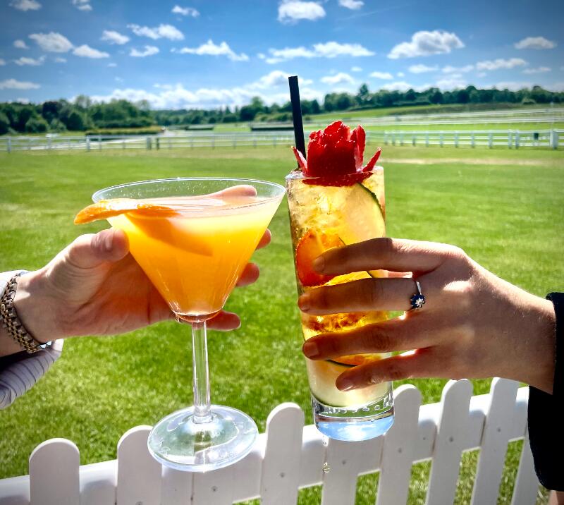 people with cocktails in front of the racecourse