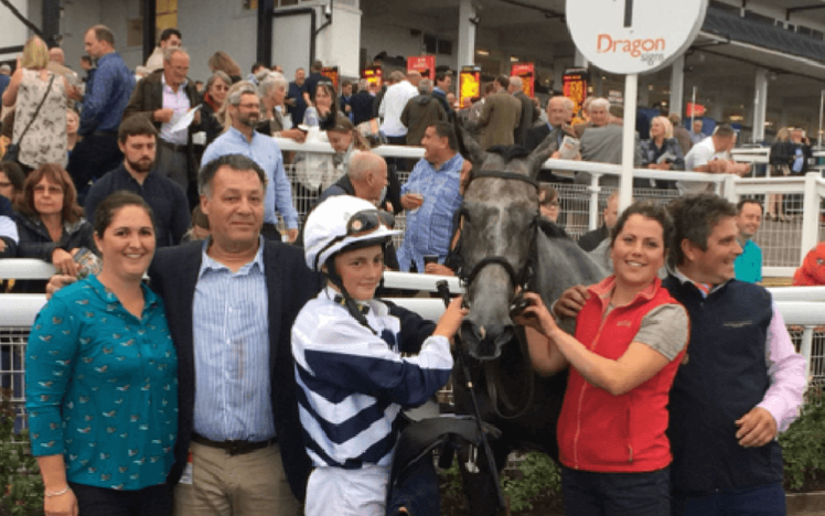 A winning team pose for a photograph at Chepstow Racecourse.