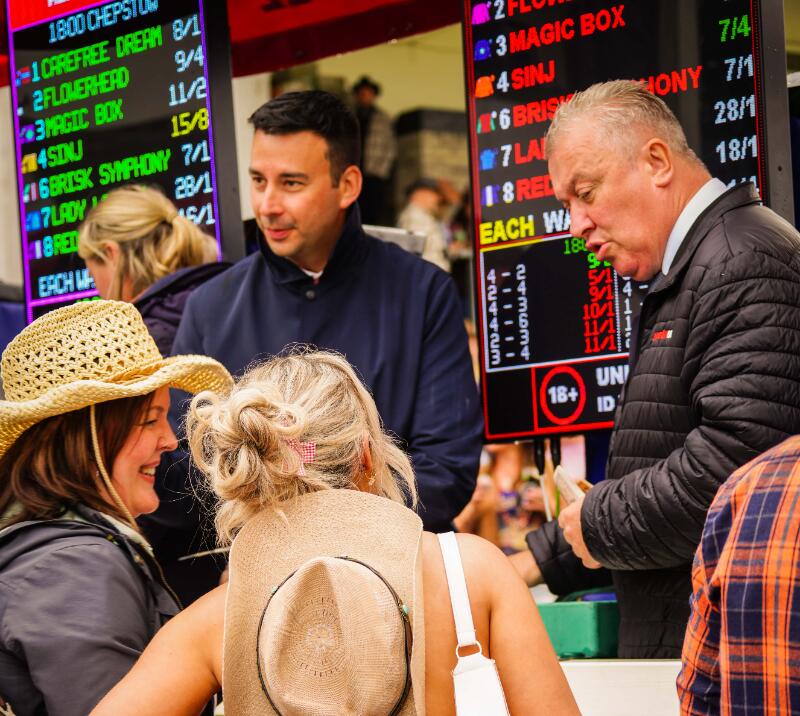 Race goers at Chepstow placing a bet with a bookmaker