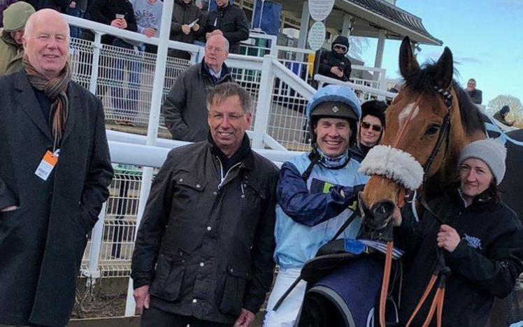 The team pose for a photograph with their horse following their success at Chepstow Racecourse.