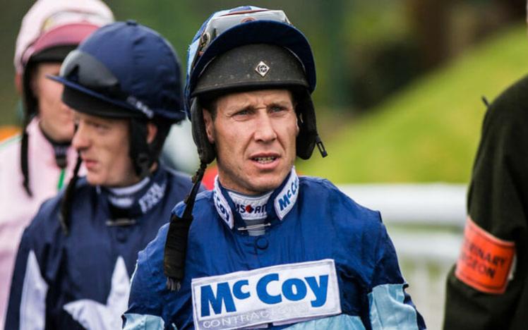 A group of jockeys walk towards an official