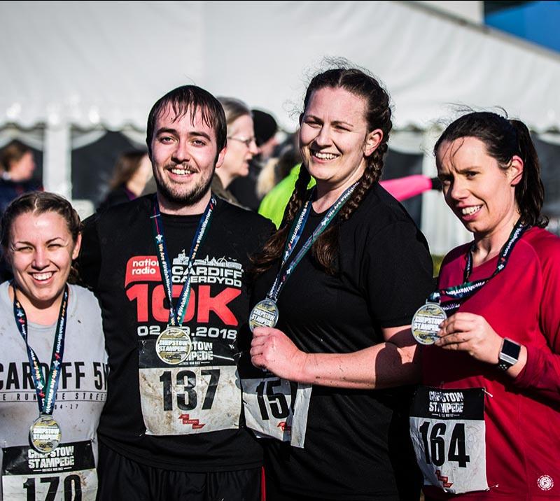 Competitors show off their medals after completing the Chepstow Stampede course.