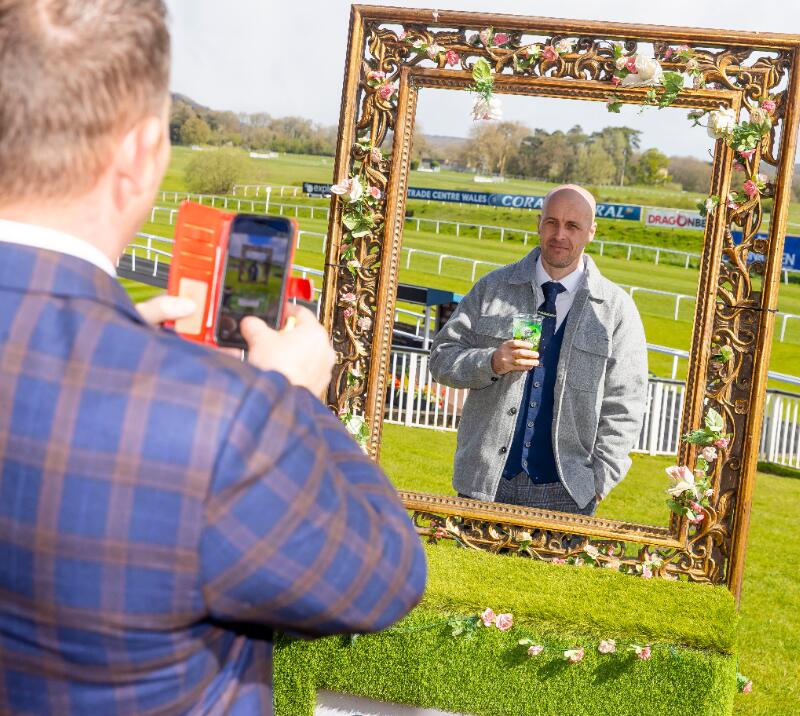 A race goer poses in a photo frame at Chepstow Races