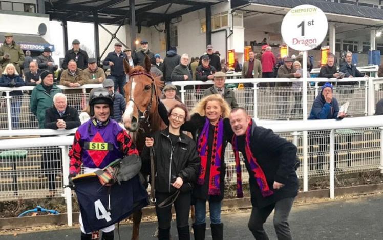 A winning team pose for photos with their thoroughbred