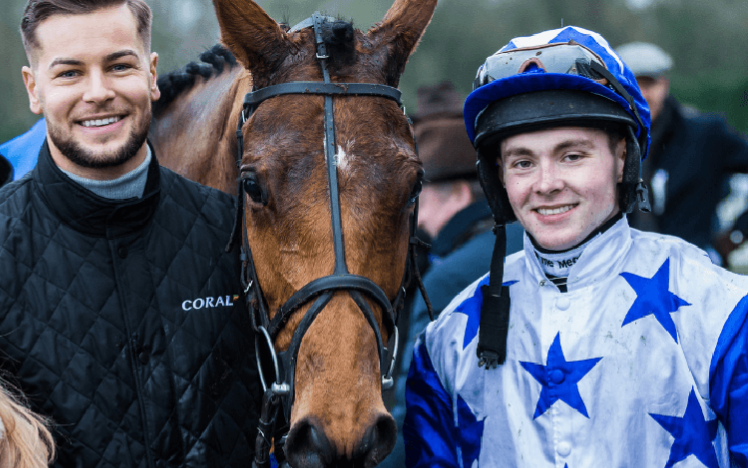 Jockey posing with winning horse and handler