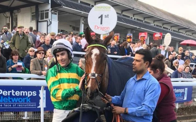 Jockey, horse and handler pose for their winners photograph