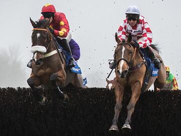 Horses over a jump at Chepstow.